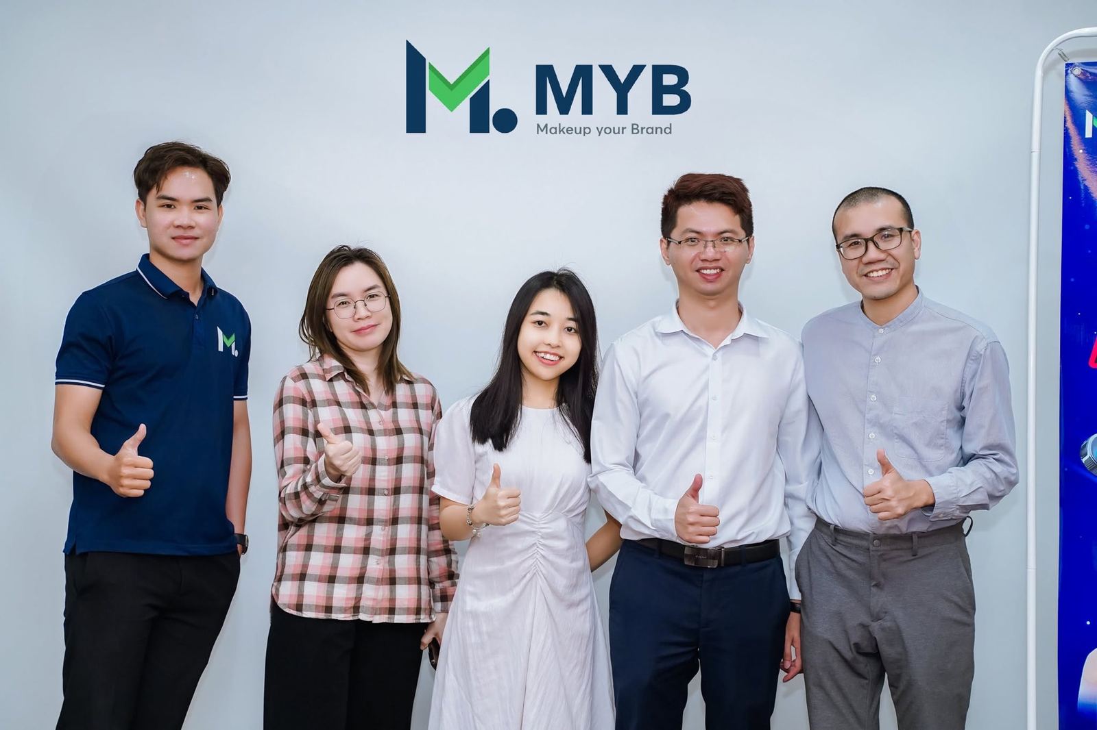 Thành viên MYB đứng trước logo Makeup your Brand.